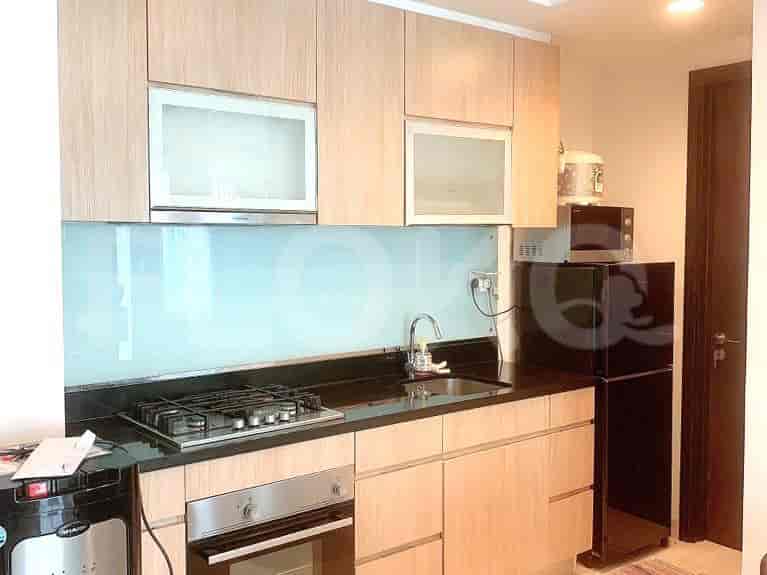 A modern kitchen featuring wood cabinets and a black countertop.