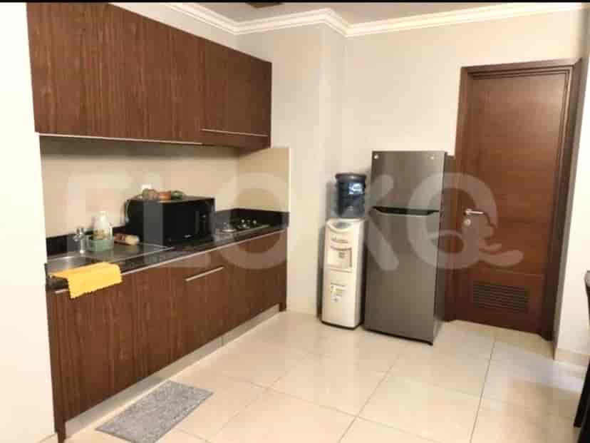 A modern kitchen with wooden cabinetry, appliances, and a water dispenser.