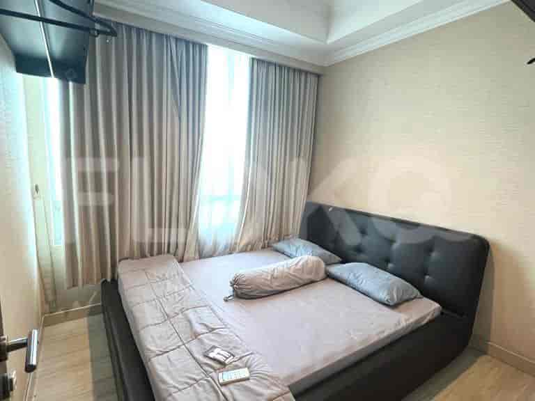 A bedroom with a double bed and sheer curtains.