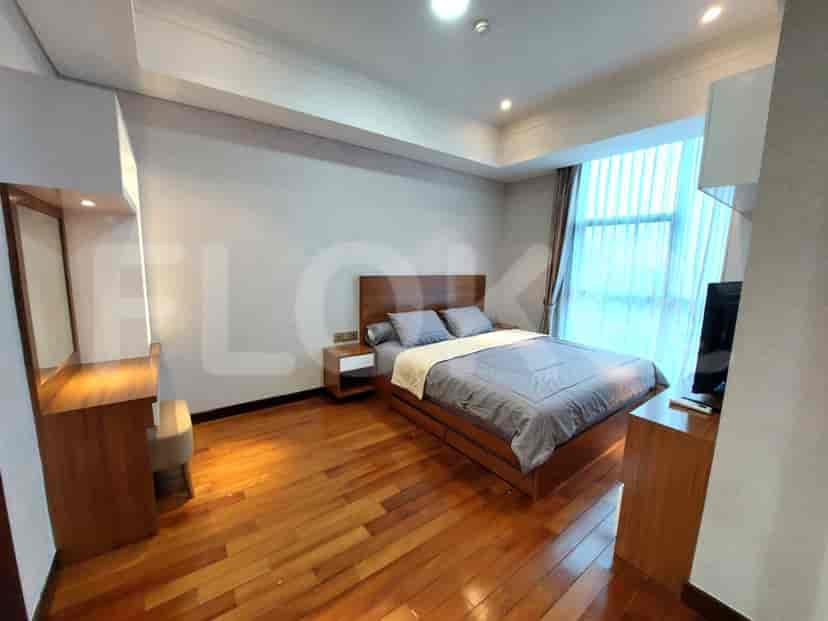 A bedroom with a bed, dresser, and large window.