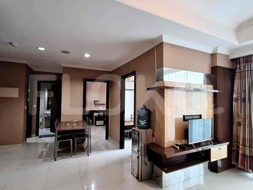A living room and dining area with a table, chairs, and access to other rooms.