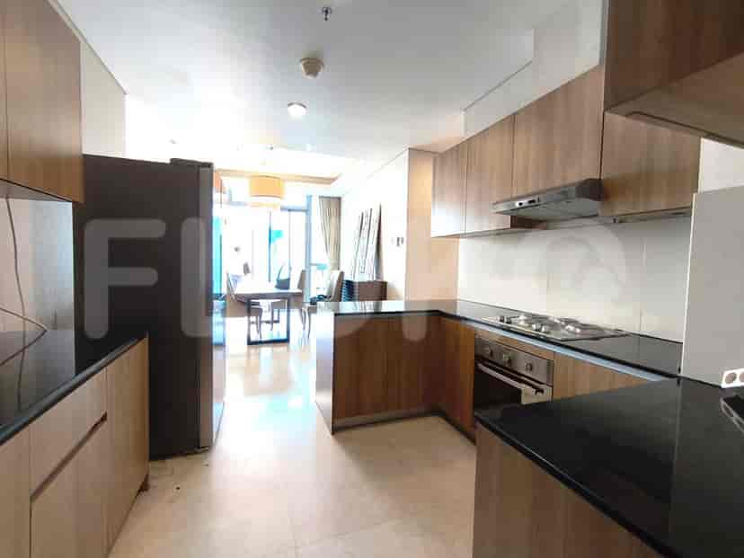 A modern kitchen with dark countertops, wooden cabinets and modern appliances.
