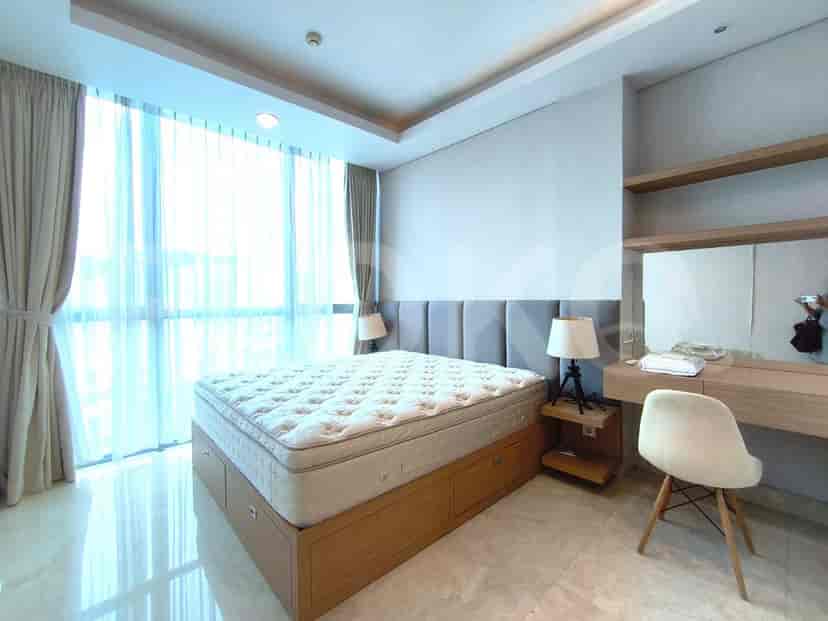 A bedroom featuring a king-size bed, bedside tables, and large windows.