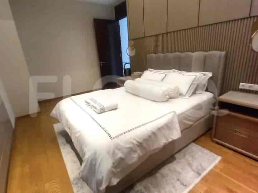 A cozy bedroom with a double bed, nightstand, and wooden accent wall.