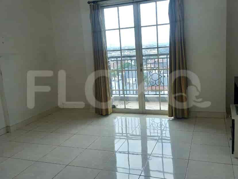 Living area with a large glass door and curtains.