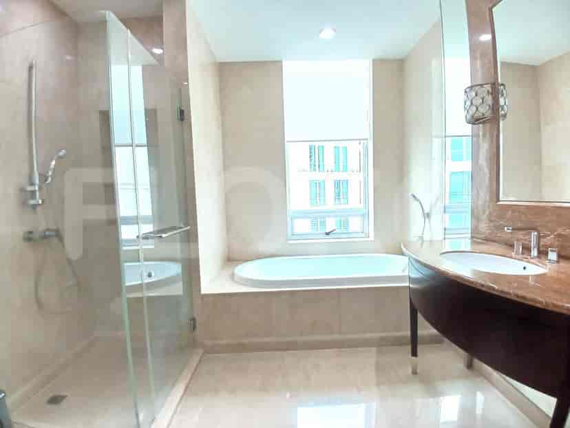 Kamar mandi mewah dengan bak mandi, pancuran kaca, dan cermin besar.