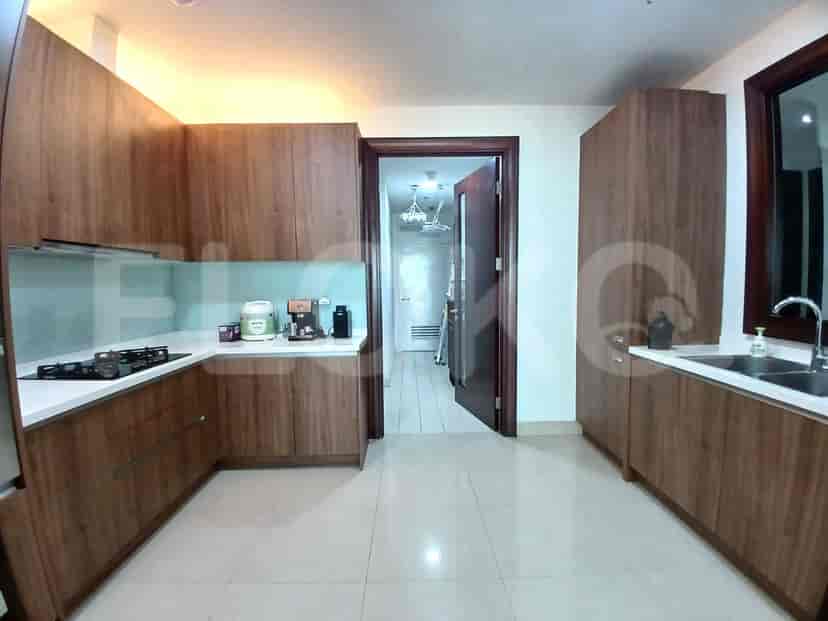 Dapur modern dengan lemari kayu, kompor gas, dan backsplash biru muda.