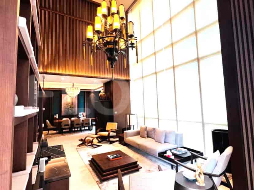 A luxurious living room with high ceilings, a large chandelier, and elegant furniture.