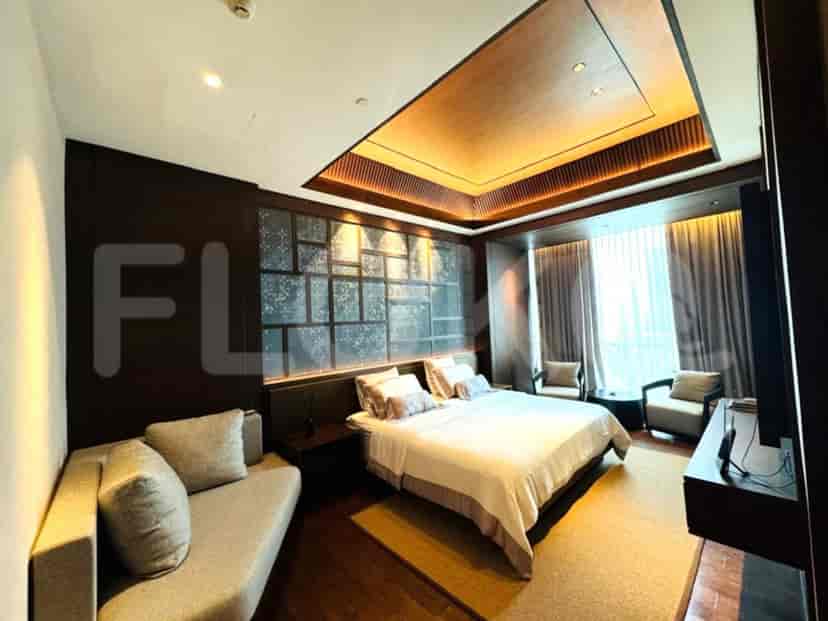 A modern bedroom with a king-size bed, a sitting area, and a stylish ceiling design.