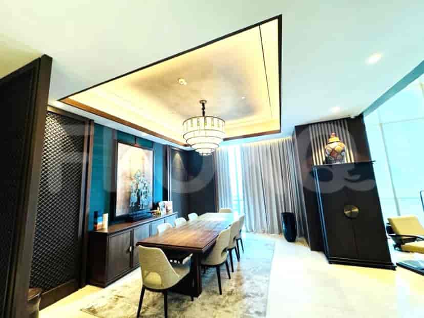 An elegant dining room with a long wooden table and a decorative ceiling.