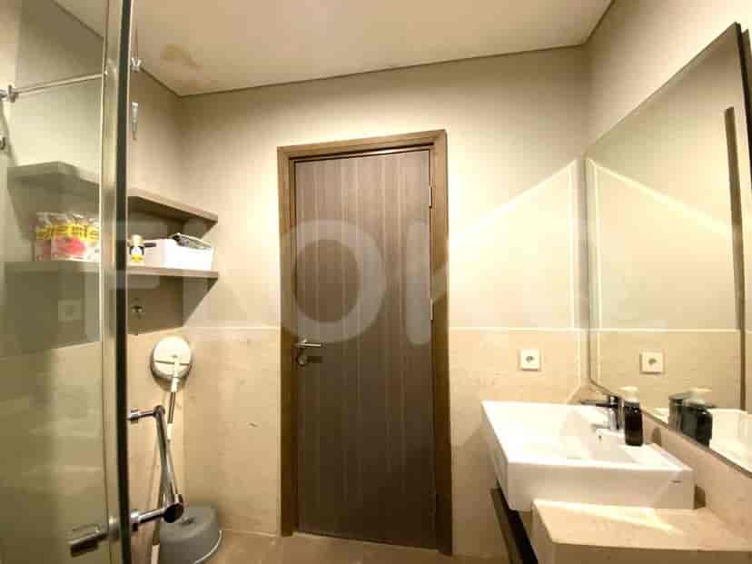 Kamar mandi modern dengan cermin besar, wastafel, dan pancuran.