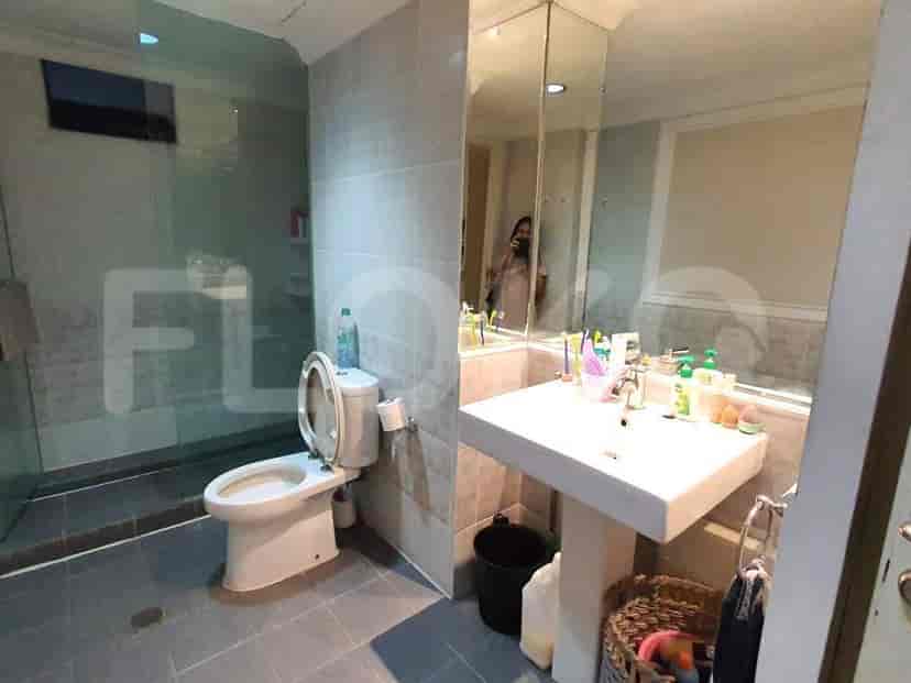 A modern bathroom with a glass-enclosed shower, floating sink, and tiled walls.