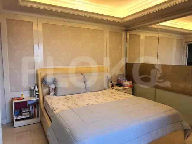 A well-appointed bedroom with a large bed, mirrored wall, and patterned wall paneling.