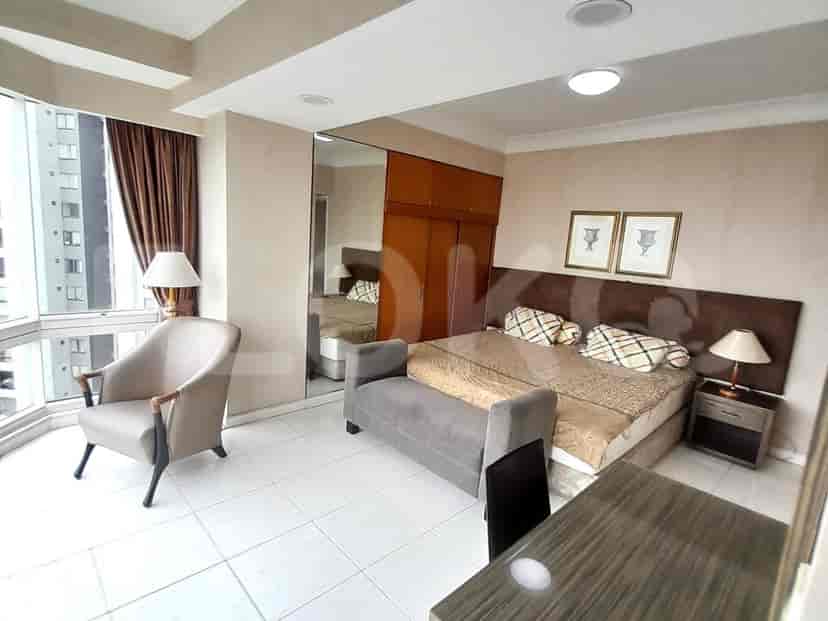 Kamar tidur dengan tempat tidur besar, sofa, dan lemari cermin.