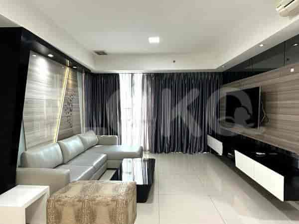 Spacious living room with grey sofa, wall-mounted TV, and large windows with sheer and night curtains.