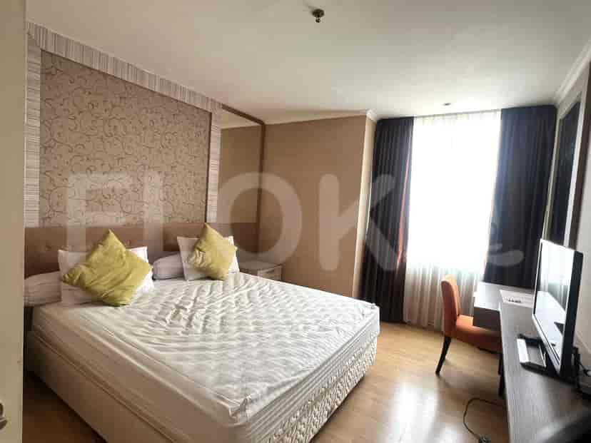 A modern bedroom featuring a large bed with yellow pillows and a matching wall decoration.