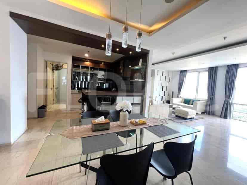 Ruang makan dan dapur gabungan dengan meja makan kaca dan dapur terbuka.