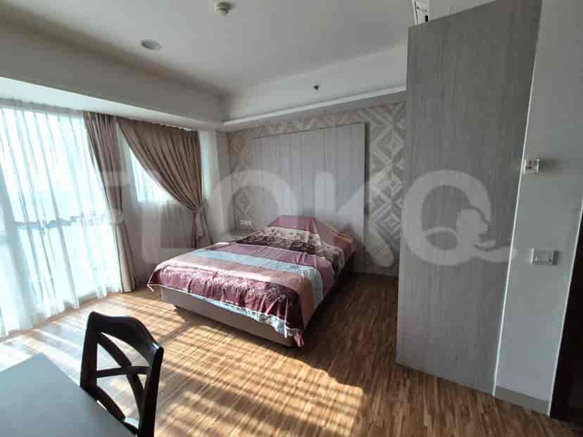 Bedroom with a double bed, large headboard, and a window with curtains.