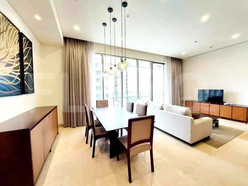 Elegant living room featuring a dining area and seating area with a large window and modern decor.