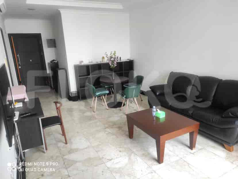 Living room with a black sofa, round dining table, and a cabinet.