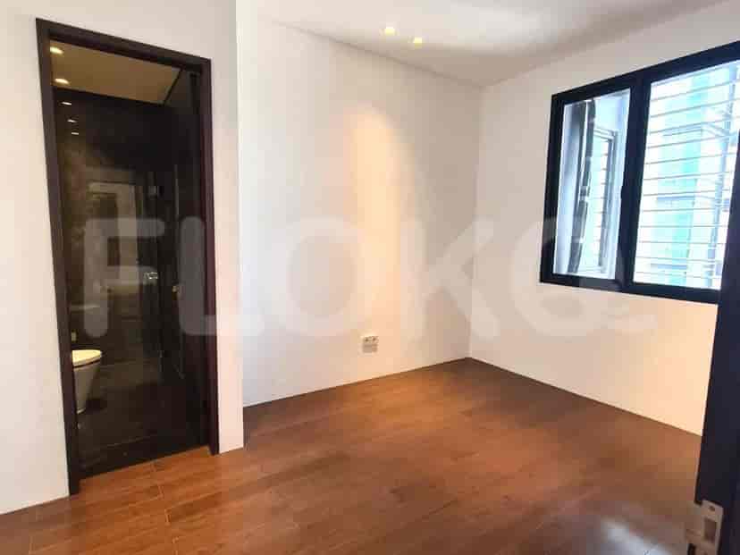 Bedroom with wooden floors, a window, and a view of a toilet.