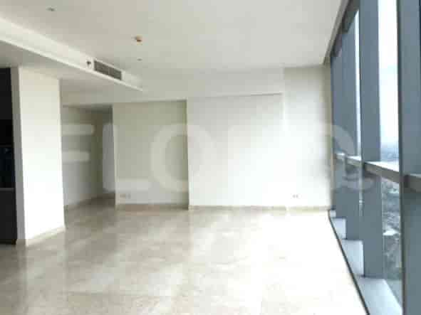 Empty living area with marble flooring and large windows.