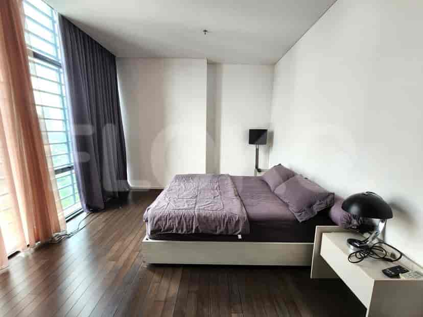 Bedroom with a large bed, wooden flooring, and a window overlooking the city.