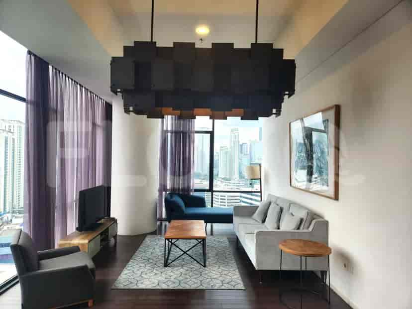 Modern living room featuring a grey sofa, accent chairs, and a striking chandelier, with a city view.