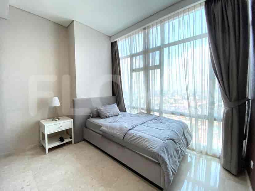 Cozy bedroom with a single bed and large windows.