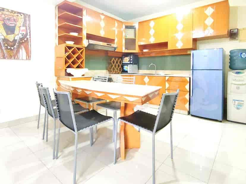 A kitchen with cabinets, a dining table, and appliances.