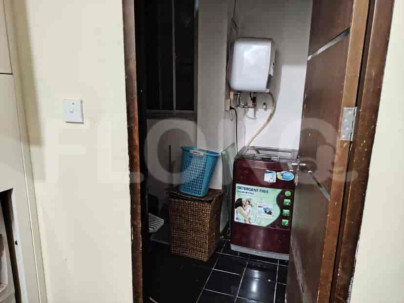A small laundry room featuring a washing machine and water heater.