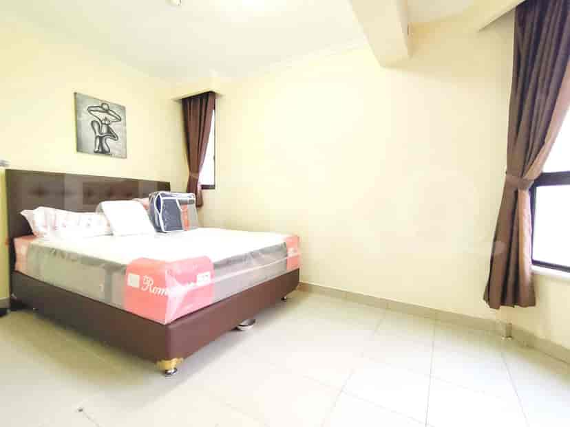 A bedroom with a double bed and curtains.