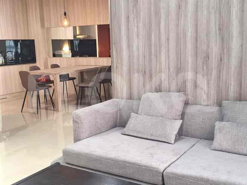 Open-plan living and dining area with a grey sofa and wooden dining table.