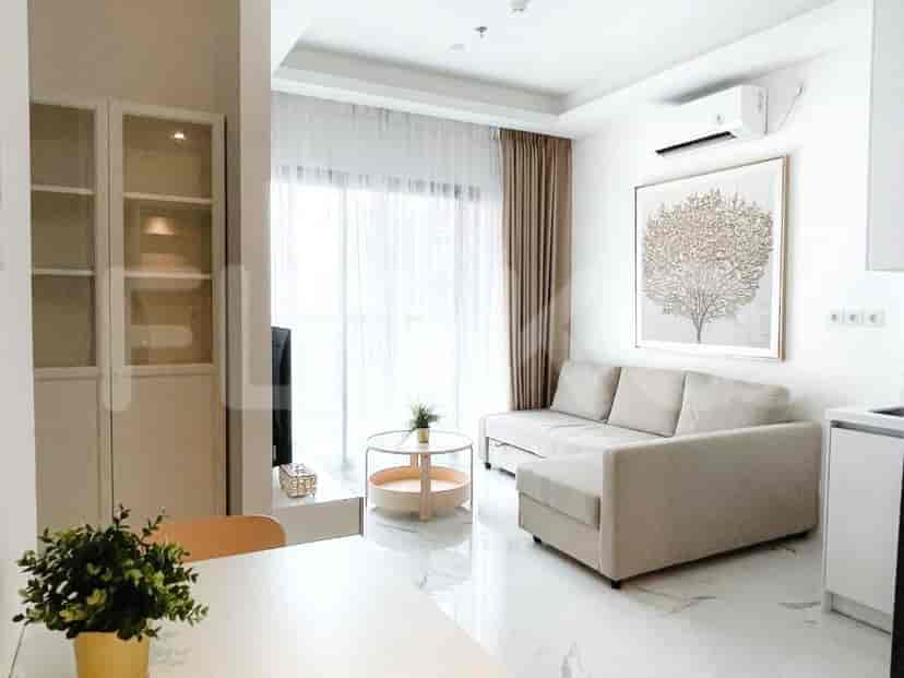 Modern living room with a beige sectional sofa, a round coffee table, and a large window.
