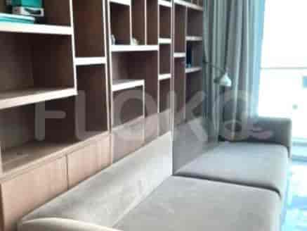 Living room with built-in shelving, L-shaped sofa, and a window with curtains.