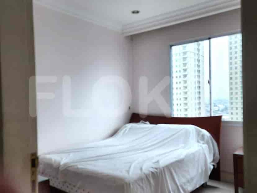 Bedroom with a bed covered in white sheets.