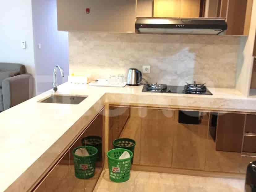 Modern kitchen with marble countertops and a black stove.