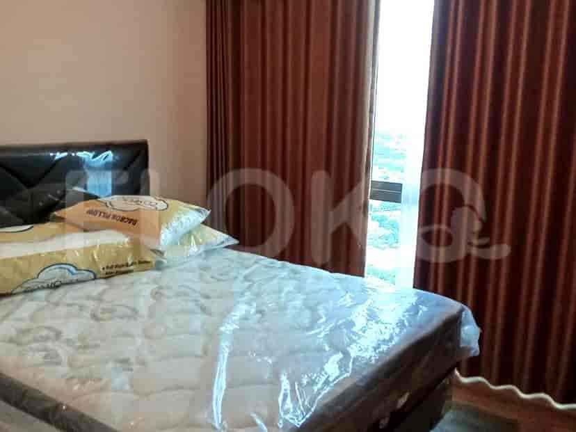 Bedroom with a bed covered in plastic and brown curtains.