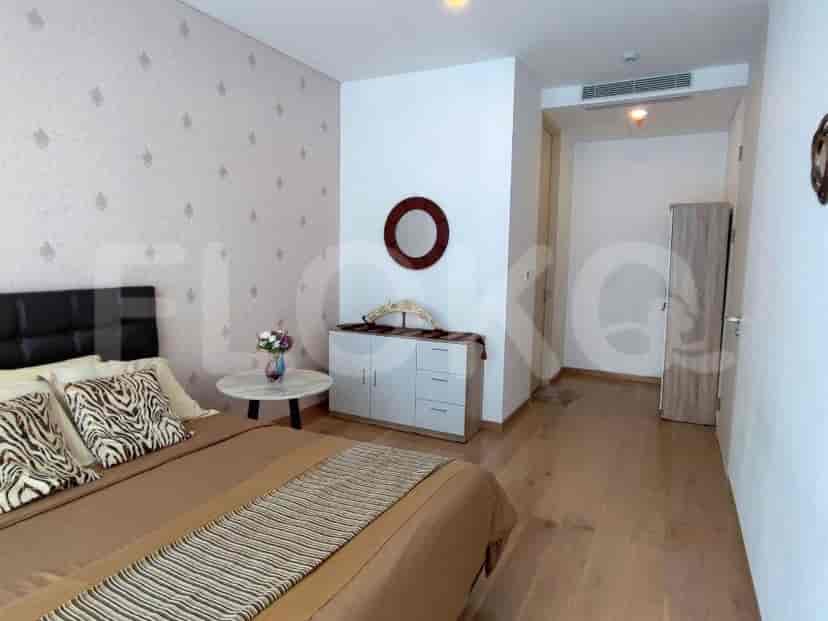 Kamar tidur dengan tempat tidur, meja samping tempat tidur, dan elemen dekoratif.