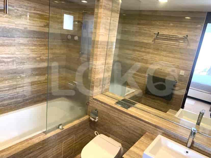 Kamar mandi yang bergaya dengan bak mandi, dinding marmer, dan cermin besar.