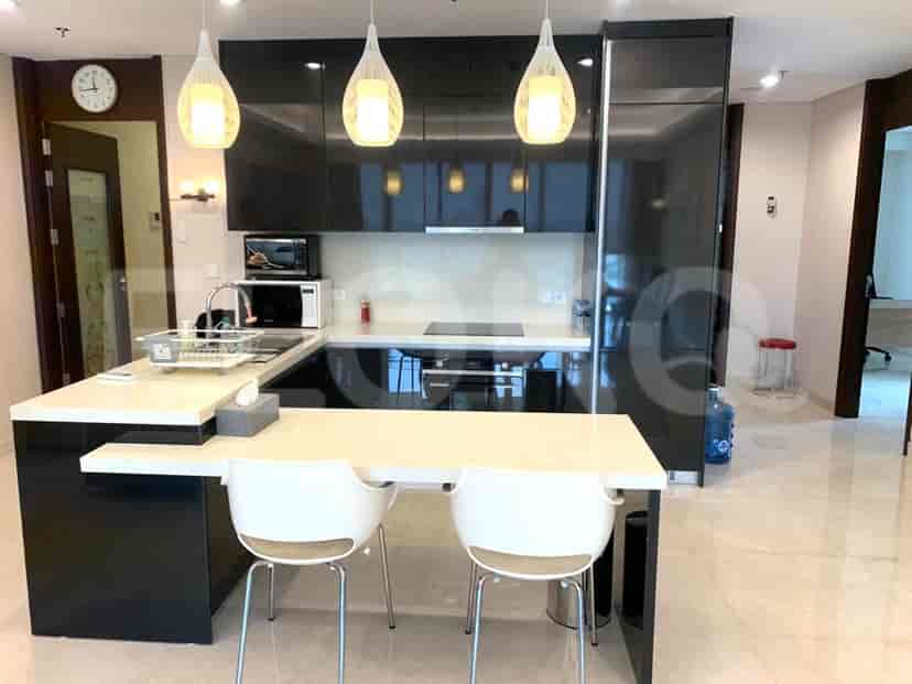 Dapur modern dengan lemari hitam, meja putih dan meja makan