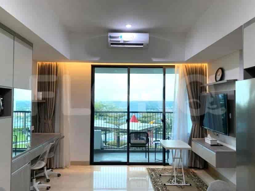 Ruang tamu yang cerah dengan pintu kaca geser dan TV yang dipasang.