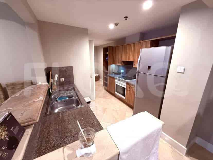 Dapur ringkas dengan peralatan stainless steel dan lemari kayu.