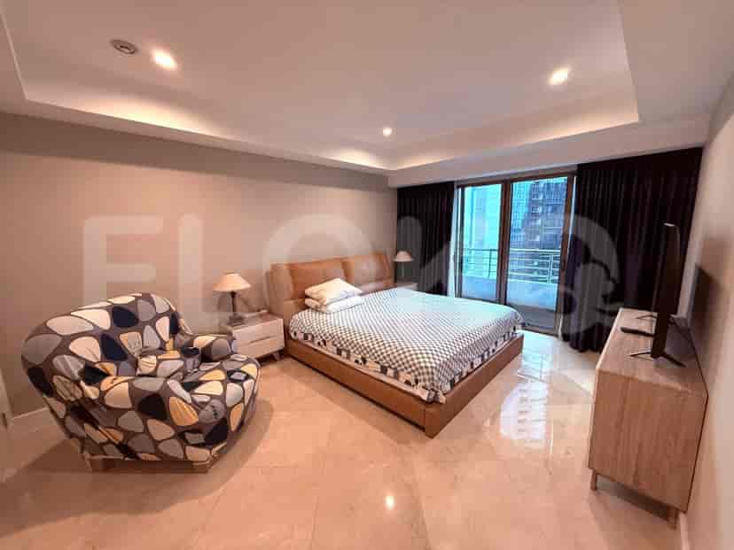 Kamar tidur dengan tempat tidur ganda, kursi, dan jendela besar.