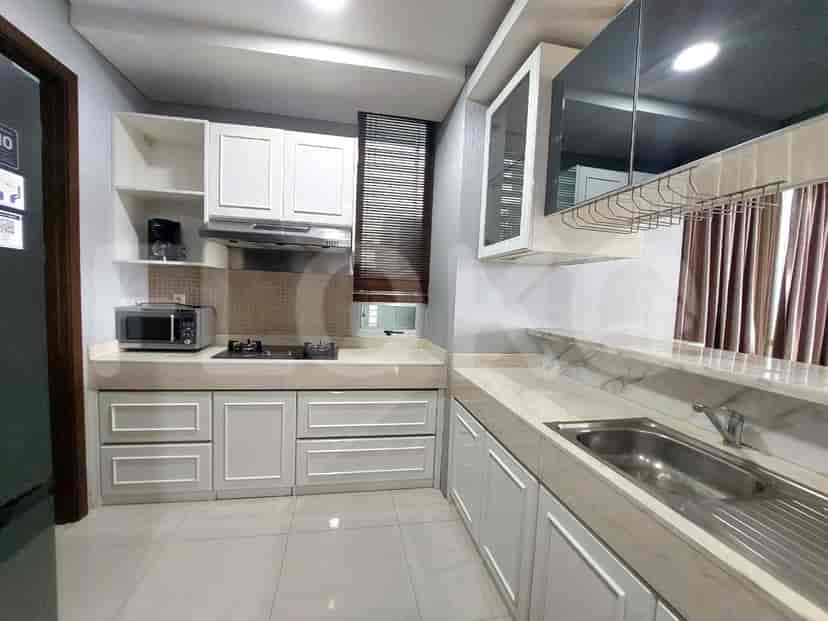 Modern kitchen with white cabinets, marble countertops, and stainless steel appliances.