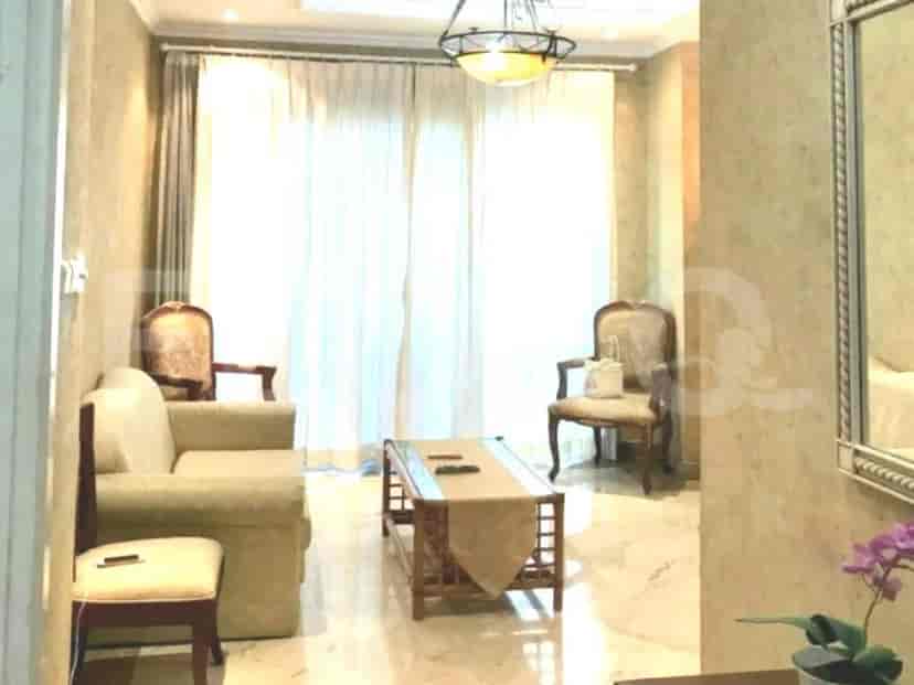 A living room with a sofa, chairs, a coffee table, and a window.