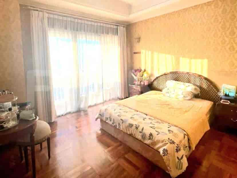 A bedroom with a bed, nightstand, and large window.