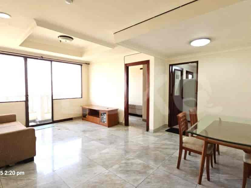 A living room with a sofa, entertainment unit, and dining area.