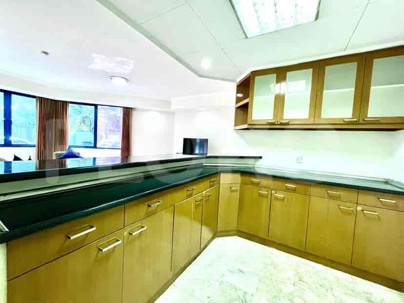 A modern kitchen and bar area with wooden cabinets and a black countertop.