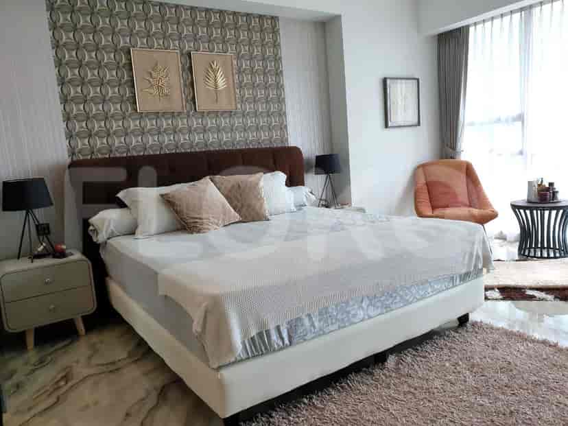 A cozy bedroom with a large bed, bedside tables, and decorative wall art.